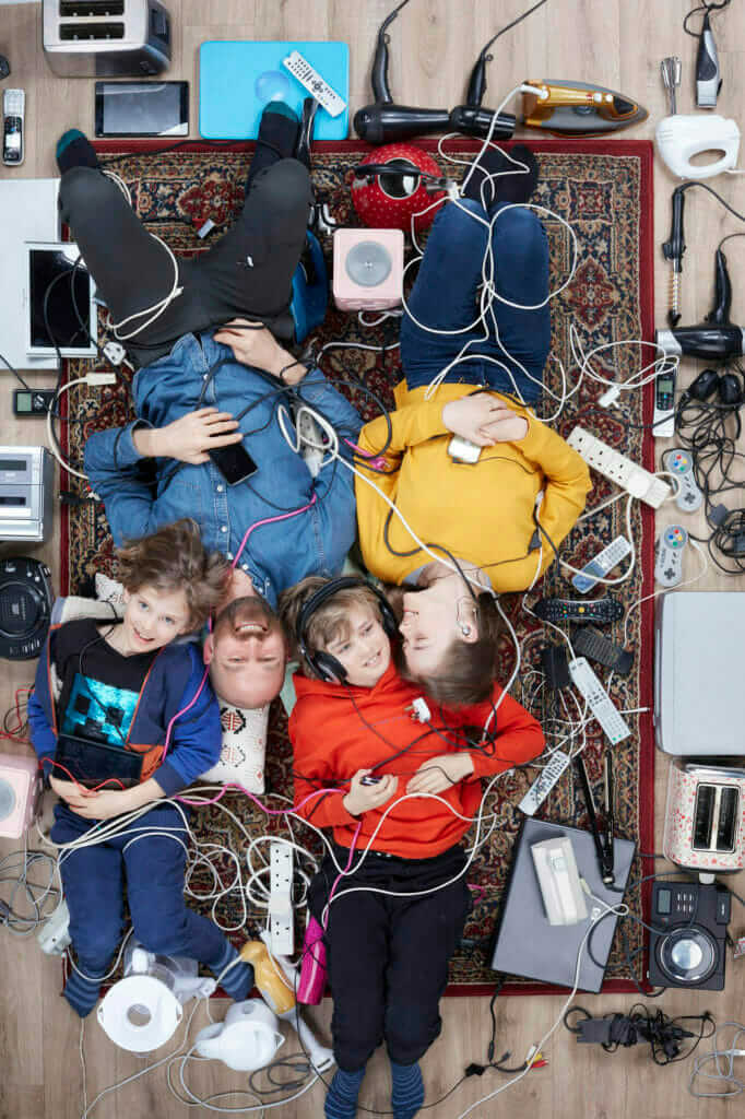 overhead shot of Rupert Boltes and his three light skinned children surrounded by household electricals photo by Gregg Segal