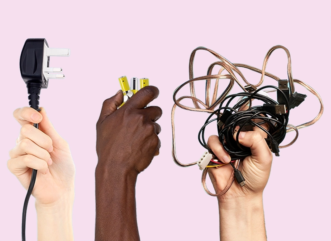 anything battery cable 2024 1072x780 a light skinned hand holding a plug in the air, dark skinned hand holding a battery up in the air a light skinned hand holding a mass of cables up in the air all on a pink background