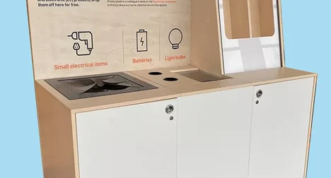 White and plywood electrical drop off bin against a bright blue background, text on the bin reads: Recycle electricals responsibly and care for the environment.