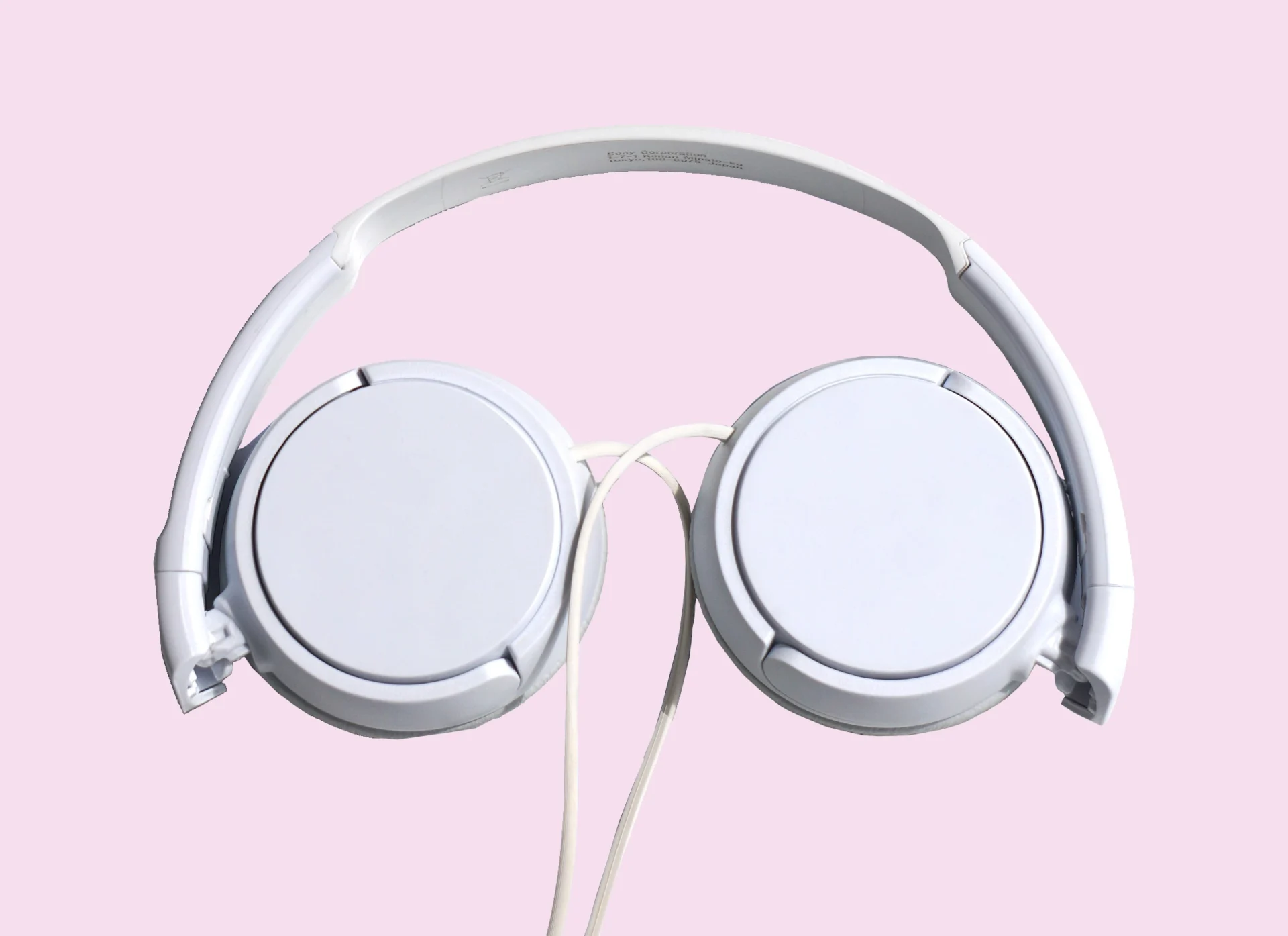 headfphones-kiran-ck-RZmiDOpv1lM-unsplash white over-ear heaphones against a pale pink background