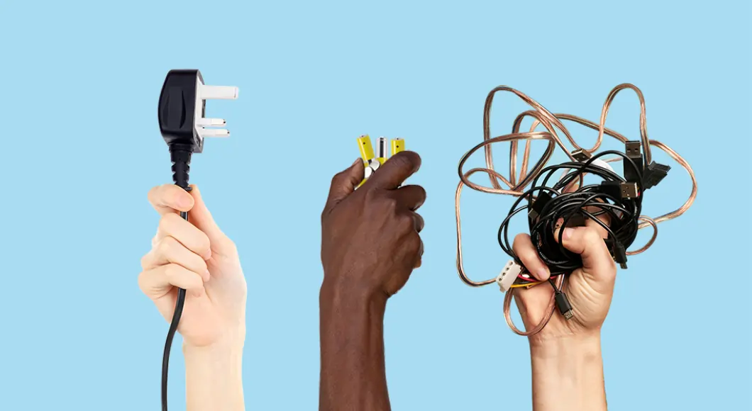 a pale skinned hand holding a plug, a dark skinned hand holding some batteries and a pale skinned hand holding some cables on a blue background